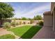 Landscaped backyard with green artificial grass, a garden, and gravel at 6482 S Claiborne Ave, Gilbert, AZ 85298