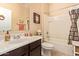 Well-lit bathroom with a shower-tub combo, white tiling, and dark wood cabinets at 6482 S Claiborne Ave, Gilbert, AZ 85298