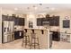 Modern kitchen featuring dark cabinetry, stainless steel appliances, granite countertops, and a breakfast bar at 6482 S Claiborne Ave, Gilbert, AZ 85298