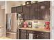 The kitchen features stainless steel refrigerator, dark wood cabinets, granite countertops at 6482 S Claiborne Ave, Gilbert, AZ 85298