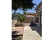 Fenced backyard featuring brick patio, concrete walkway, and low-maintenance desert landscaping at 6853 S Roosevelt St, Tempe, AZ 85283