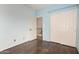 Bedroom with wood floor, closet, and an open doorway at 6853 S Roosevelt St, Tempe, AZ 85283