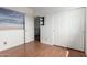 Bedroom with wood floor, closet, shelving, and an open doorway at 6853 S Roosevelt St, Tempe, AZ 85283