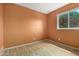 A cozy bedroom with wood-look floors, neutral paint, and a window view of lush greenery at 6853 S Roosevelt St, Tempe, AZ 85283