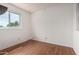 Bedroom with wood floor, natural light from a window, and white walls at 6853 S Roosevelt St, Tempe, AZ 85283