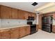 Bright kitchen boasts wooden cabinets, black appliances, and ample counter space at 6853 S Roosevelt St, Tempe, AZ 85283
