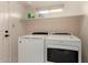 Laundry room features a modern washer and dryer with a storage shelf above at 6853 S Roosevelt St, Tempe, AZ 85283