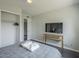 Well-lit bedroom with closet, TV on modern wood stand, and neutral decor at 6945 E Osborn Rd # E, Scottsdale, AZ 85251