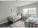 A cozy bedroom featuring two twin beds, a window and an area rug at 6945 E Osborn Rd # E, Scottsdale, AZ 85251