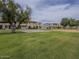 View of community green space, mature trees, and townhouses in the background at 6945 E Osborn Rd # E, Scottsdale, AZ 85251