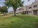 View of community green space, mature trees, and townhouses in the background at 6945 E Osborn Rd # E, Scottsdale, AZ 85251