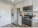 Updated kitchen with stainless steel appliances, quartz countertops, and white cabinets at 6945 E Osborn Rd # E, Scottsdale, AZ 85251