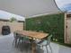 Charming patio with stylish dining set, shade, and privacy wall with greenery at 6945 E Osborn Rd # E, Scottsdale, AZ 85251