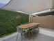 Charming patio with stylish dining set, shade, and privacy wall with greenery at 6945 E Osborn Rd # E, Scottsdale, AZ 85251