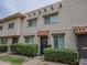 Charming townhouse with a brick facade, red tile awning, and mature landscaping at 6945 E Osborn Rd # E, Scottsdale, AZ 85251