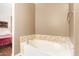 Bright bathroom featuring a soaking tub with tile accents and adjacent bedroom access at 7445 E Eagle Crest Dr # 1061, Mesa, AZ 85207