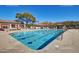 Long outdoor swimming pool surrounded by a concrete deck, lounge chairs, and covered pergola seating at 7445 E Eagle Crest Dr # 1061, Mesa, AZ 85207
