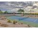 Well-maintained tennis courts with desert landscaping under a cloudy sky, perfect for an active lifestyle at 7445 E Eagle Crest Dr # 1061, Mesa, AZ 85207
