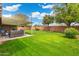 Spacious backyard featuring well-maintained grass, patio with seating, and block fence at 7520 E Diamond St, Scottsdale, AZ 85257