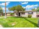 Charming single-story home featuring a well-manicured lawn and mature tree shading the front at 7520 E Diamond St, Scottsdale, AZ 85257