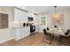Modern kitchen with white cabinets, stainless steel appliances, and a wooden dining table near a door to the outside at 7520 E Diamond St, Scottsdale, AZ 85257