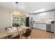 Open kitchen featuring white cabinets, stainless appliances, and an adjacent dining area overlooking the backyard at 7520 E Diamond St, Scottsdale, AZ 85257