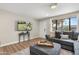 Comfortable living room with a plush gray sofa, ottoman, and natural light from a large window at 7520 E Diamond St, Scottsdale, AZ 85257