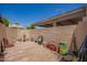 Enclosed backyard featuring a gravel and brick area, along with the homeowner's supplies, creating a functional outdoor space at 7808 E Lewis Ave, Scottsdale, AZ 85257