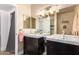 Bathroom featuring a double vanity with dark wood cabinets, modern fixtures, and neutral decor at 7808 E Lewis Ave, Scottsdale, AZ 85257