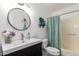 Bathroom featuring a sleek vanity with a modern faucet, a round mirror, and decorative accents at 7808 E Lewis Ave, Scottsdale, AZ 85257