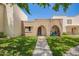 Charming townhome exterior with brick accents, grassy lawn, and covered porch entry at 7808 E Lewis Ave, Scottsdale, AZ 85257
