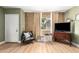 Living room showcasing warm wood floors, a brick accent wall, and neutral paint at 7808 E Lewis Ave, Scottsdale, AZ 85257