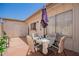 Cozy brick patio with table and chairs, complemented by an umbrella and view of the home's exterior at 7808 E Lewis Ave, Scottsdale, AZ 85257