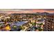 Expansive aerial view of lit-up city buildings, trees, and waterfront at twilight at 7860 E Camelback Rd # 404, Scottsdale, AZ 85251