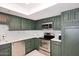 Bright kitchen with stainless steel appliances, green cabinetry, and modern white countertops at 7860 E Camelback Rd # 404, Scottsdale, AZ 85251