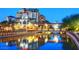 Scenic waterfront view of a building complex with lights reflected in the water at twilight at 7860 E Camelback Rd # 404, Scottsdale, AZ 85251