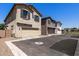 View of multiple two-story townhomes featuring private garages and neutral exteriors against a blue sky at 8313 E Impala Ave, Mesa, AZ 85209