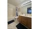 Bathroom showcasing a vanity with a large mirror, shower-tub combo, and tile flooring at 8874 N 48Th Ln, Glendale, AZ 85302