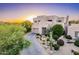 Modern two-story home with desert landscaping, a multi-car garage and sunset in background at 10772 E Running Deer Trl, Scottsdale, AZ 85262
