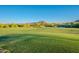 Beautifully manicured golf course featuring green fairways and serene water features with mountain views in the distance at 10772 E Running Deer Trl, Scottsdale, AZ 85262