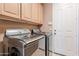 Well-equipped laundry room with modern appliances and ample cabinet space at 10772 E Running Deer Trl, Scottsdale, AZ 85262