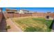 Spacious backyard with a well-maintained lawn, brick perimeter wall, and a barbecue grill at 10956 E Thunderbolt Ave, Mesa, AZ 85212