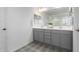 Bathroom featuring double sinks, gray cabinetry, modern fixtures, and decorative patterned floors at 10956 E Thunderbolt Ave, Mesa, AZ 85212