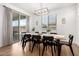 Dining room featuring a wooden table, black chairs, a modern light fixture, and sliding glass doors at 10956 E Thunderbolt Ave, Mesa, AZ 85212