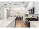 Modern kitchen with stainless steel appliances, white cabinets and an island, flowing into the dining area at 10956 E Thunderbolt Ave, Mesa, AZ 85212