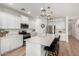 Bright open kitchen with large island, stainless appliances, modern pendant lights and wooden floors at 10956 E Thunderbolt Ave, Mesa, AZ 85212