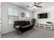 Well-lit living room featuring a modern ceiling fan, plush seating, and a sleek entertainment center at 10956 E Thunderbolt Ave, Mesa, AZ 85212