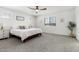 Cozy main bedroom features plush carpeting, a ceiling fan, and windows for natural light at 10956 E Thunderbolt Ave, Mesa, AZ 85212