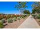 Scenic walking path featuring lush landscaping, colorful flowers, and well-maintained sidewalks at 10956 E Thunderbolt Ave, Mesa, AZ 85212