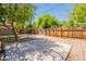 Backyard featuring mature trees, a freshly poured concrete pad, and a wooden fence at 1110 W Heatherbrae Dr, Phoenix, AZ 85013